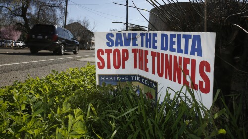 FILE – A sign opposing a plan to build a giant tunnel to ship water to Southern California is displayed near Freeport, California, on May 2, 2016. California Gov. Gavin Newsom has a plan to speed up some construction projects throughout the state. But some lawmakers and environmental advocates fear his plan would benefit the tunnel project, which they oppose. (AP Photo/Rich Pedroncelli, file)