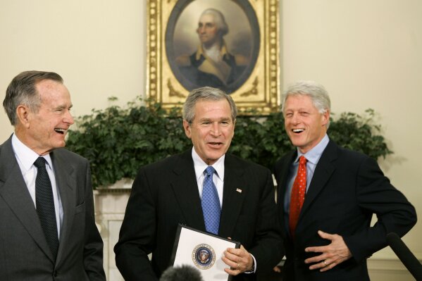 FILE - In this March 8, 2005, file photo former presidents President Bill Clinton, right, and President George H.W. Bush, left, meet with President George W. Bush in the Oval Office at the White House in Washington. George W. Bush turned to one of the world's most exclusive clubs for help raising money after an Indian Ocean tsunami killed more than 200,000 people in 2004. (AP Photo/J. Scott Applewhite, File)