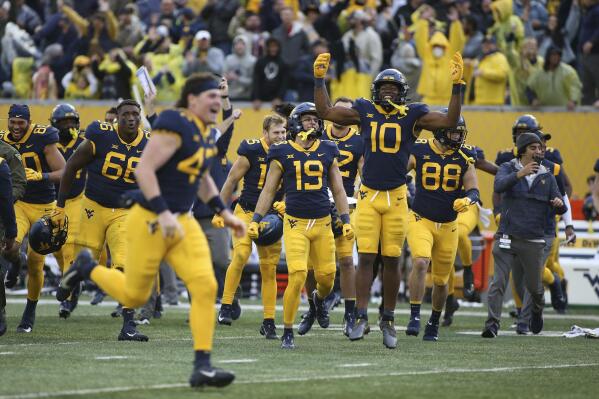 West Virginia players celebrate after a win against Iowa State in an NCAA college football game in Morgantown, W.Va., Saturday, Oct. 30, 2021. (AP Photo/Kathleen Batten)