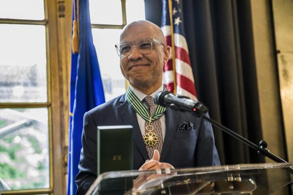 This photo provided by Ford Foundation shows Darren Walker, the president of the Ford Foundation receiving France’s highest cultural honor in recognition of his support of the arts and artists on Tuesday, May 24, 2022 at the French embassy in New York.  “Being in this firmament is absolutely humbling,” Walker told The Associated Press. “I’m simply a servant to the idea of art and justice in the world, because we can’t have justice without art.”    (Kisha Bari/Ford Foundation via AP)