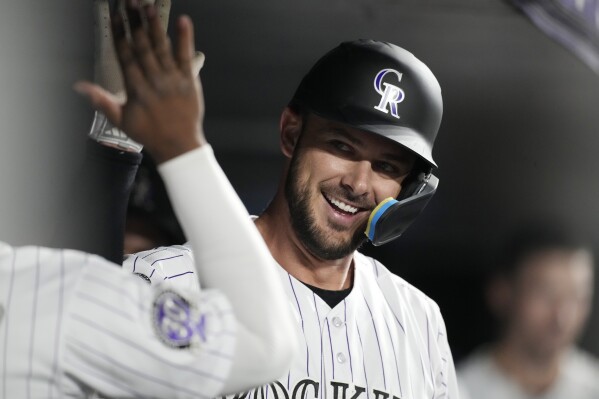 Colorado Rockies' Kris Bryant is congratulated as he returns to the dugout after hitting a solo home run off Chicago Cubs relief pitcher Daniel Palencia during the sixth inning of a baseball game Tuesday, Sept. 12, 2023, in Denver. (AP Photo/David Zalubowski)