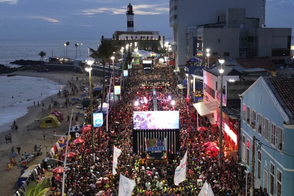 A sound truck popularly referred to as an electric trio makes its way through a street crowded with revelers during the “Vumbora” Carnival street party in Salvador, Brazil, Saturday, Feb. 10, 2024. (AP Photo/Eraldo Peres)