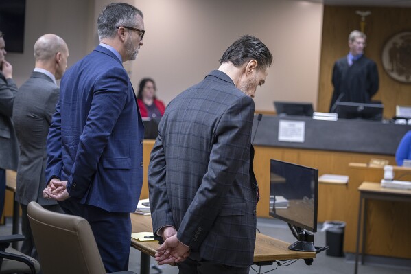 Nicolae Miu, right, stands alongside his defense and waits as the jury leaves the courtroom after requesting to watch the Jawahn Cockfield video during his trial at the St. Croix County District Court in Hudson, Wis., on Thursday, April 11, 2024. Miu, a 54-year-old Prior Lake man, has been convicted in the slaying of a 17-year-old high school student and stabbing of four other people who were tubing on a western Wisconsin river. (Elizabeth Flores/Star Tribune via AP)