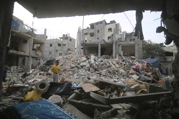 Palestinians inspect the rubble Abu Helal family in Rafah refugee camp, Gaza Strip, Monday, Oct. 9, 2023. The strike killed dozens of people.(AP Photo/Hatem Ali)