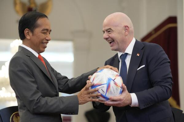 Indonesian President Joko Widodo, left, receives a gift of a ball from FIFA President Gianni Infantino during their meeting at Merdeka Palace in Jakarta, Indonesia, Tuesday, Oct. 18, 2022. (AP Photo/Achmad Ibrahim)