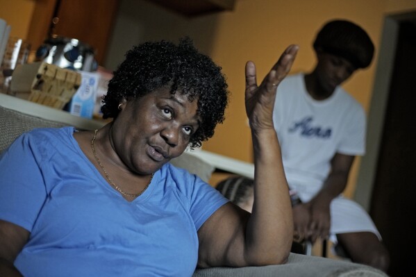 Bobbie Boyd talks about this summer's heat in her apartment which she shares with her 15-year-old grandson Jeremiah Williams, right, Wednesday, Aug. 9, 2023, in Fayetteville, Ark. On a fixed income, Boyd sacrifices meals, health care, and car insurance among other necessities to pay rent and keep cool in the midst of this summer's prolonged heat waves. (AP Photo/Charlie Riedel)