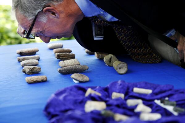 John Russell, an expert on Iraqi antiquities, looks at cuneiform tablets that are being returned to Iraq by Immigration and Customs Enforcement (ICE), during a ceremony at the Residence of the Iraqi Ambassador to the United States, in Washington, Wednesday, May 2, 2018. The artifacts were smuggled into the United States in violation of federal law and shipped to Hobby Lobby stores, a nationwide arts-and-crafts retailer. The shipping labels on these packages falsely described the cuneiform tablets as tile samples. (AP Photo/Jacquelyn Martin)