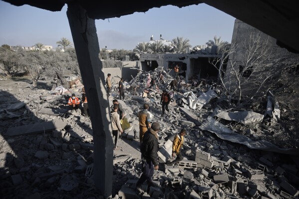 Palestinians inspect the damage of a destroyed house following Israeli airstrikes on Khan Younis, Southern Gaza Strip, Sunday, Dec. 31, 2023. (AP Photo/Mohammed Dahman)