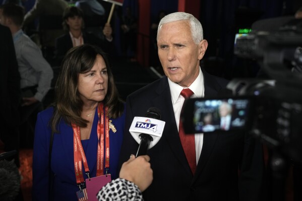 Former Vice President Mike Pence talks to reporters in the spin room after a Republican presidential primary debate hosted by FOX News Channel Wednesday, Aug. 23, 2023, in Milwaukee, with his wife Karen. (AP Photo/Morry Gash)