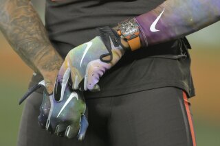 In this Sept. 22, 2019 file photo Nike logos adorn the gloves of Cleveland Browns wide receiver Odell Beckham Jr. (13) before an NFL football game against the Los Angeles Rams in Cleveland. Nike, the NFL and other businesses are giving their employees a paid day off on Juneteenth for the first time, the latest example of how American employers are responding to protests that have placed additional attention on racial injustice in the U.S. NFL Commissioner Roger Goodell wrote in a note Friday, June 12, 2020 that its offices would be closed June 19. (AP Photo/David Richard, file)