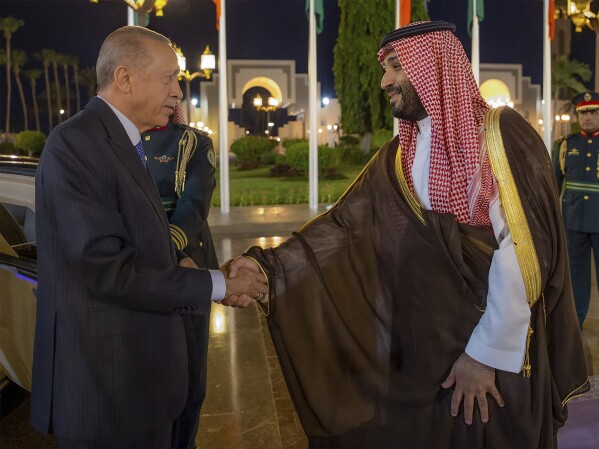 In this photo released by the state-run Saudi Press Agency, Turkish President Recep Tayyip Erdogan, left, and Saudi Crown Prince Mohammed bin Salman shake hands during a welcome ceremony at Al Salam Palace in Jeddah, Saudi Arabia, Monday, July 17, 2023. Erdogan traveled to Saudi Arabia on Monday in a three-stop tour of Gulf states to seek trade and investment opportunities for Turkey's floundering economy. (Saudi Press Agency via AP)