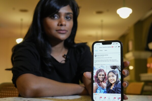 Grace Subathirai Nathan, shows a photo of her mother on her cell phone during an interview with The Associated Press in Kuala Lumpur, Malaysia, Monday, Feb. 26, 2024. Over the past decade, Grace Subathirai Nathan has graduated from law school, gotten married, opened her own law firm and given birth to two children.  But part of her is frozen in time, still in denial about losing her mother on the missing Malaysia Airlines plane in 2014. (AP Photo/Vincent Thian)