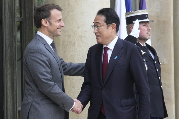 French President Emmanuel Macron, left, shakes hands with Japanese Prime Minister Fumio Kishida before a working lunch, Thursday, May 2, 2024 at the Elysee Palace in Paris. (AP Photo/Michel Euler)