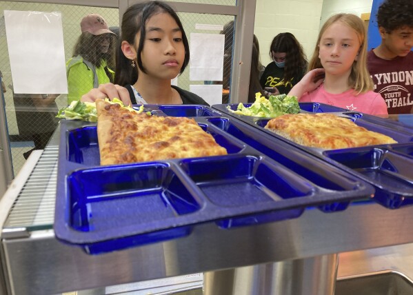 FILE - Students pick up lunch at the Albert D. Lawton Intermediate School, in Essex Junction, Vt., June 9, 2022. Vermont's Republican governor on Wednesday, June 14, 2023, allowed a bill that will provide free school meals to all students to become law without his signature, saying that a veto would likely be overridden. Vermont now joins five other states providing free school meals for all students, regardless of their families' income. (AP Photo/Lisa Rathke, File)