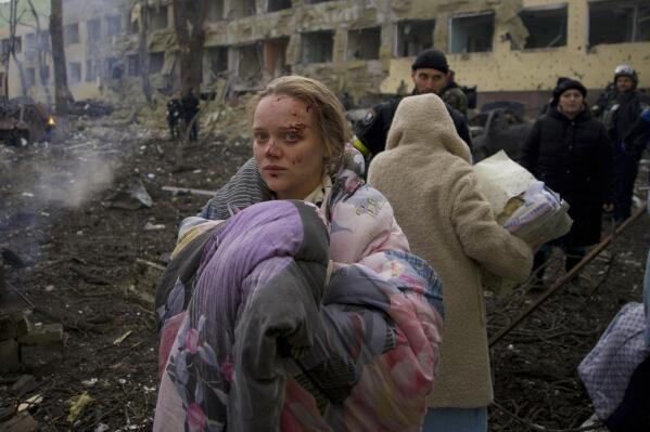 FILE - Marianna Vishegirskaya stands outside a maternity hospital that was damaged by shelling in Mariupol, Ukraine, Wednesday, March 9, 2022. Visheirskaya was taken to another nearby hospital where she gave birth the following day to a baby girl she named Veronika. “We were lying in wards when glass, frames, windows and walls flew apart,” she told AP, lying next to her newborn. "We don’t know how it happened. We were in our wards and some had time to cover themselves. Some didn’t.” (AP Photo/Mstyslav Chernov, File)