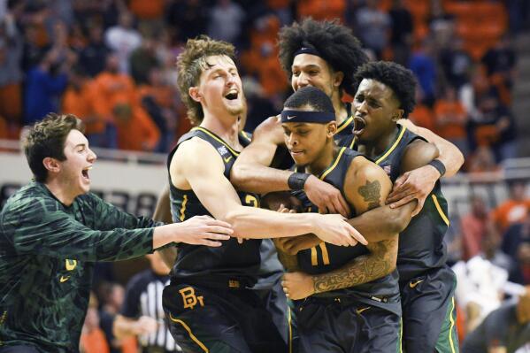 Baylor teammates celebrate with guard James Akinjo (11) who scored in overtime to give them a victory over Oklahoma State during an NCAA college basketball game Monday, Feb. 21, 2022, in Stillwater, Okla. (AP Photo/Brody Schmidt)
