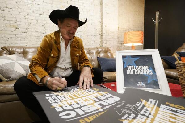 Kix Brooks, of the country music duo Brooks & Dunn, autographs posters before a dinner and program hosted by the Country Music Association Foundation Wednesday, Oct. 19, 2022, in Nashville, Tenn. The CMA Foundation honored educators from across the country who were selected as music teachers of excellence. (AP Photo/Mark Humphrey)