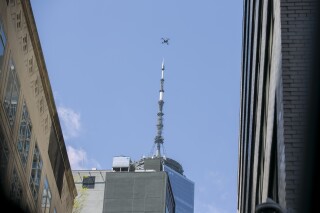 FILE - An NYPD or FDNY drone flies over the site of a partially collapsed parking garage as One World Trade Center is visible in the background in New York City, April 19, 2023. The New York City police department plans to pilot the unmanned police surveillance drones in response to complaints about large gatherings, including private events, over Labor Day weekend, officials announced Thursday, Aug. 31. (AP Photo/Ted Shaffrey, File)