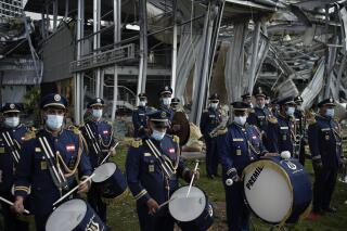 A scouts band performs in honor of the victims of the last week's explosion that killed over 150 people and devastated the city, near the blast site in Beirut, Lebanon, Tuesday, Aug. 11, 2020. (AP Photo/Felipe Dana)
