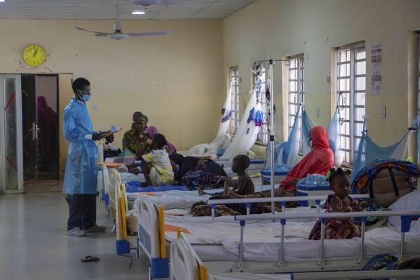 In this handout photo released by MSF, Dr. Aminu, left, on a routine check up on patients at the diphtheria treatment centre of the Murtala muhammad specialist hospital in Kano, Nigeria, Monday, Aug. 21, 2023. Authorities in several West African countries are trying to manage their huge diphtheria outbreaks, including in Nigeria where a top health official said Thursday Nov. 23, 2023 that millions are being vaccinated to cover wide gaps in immunity against the disease. (Ehab Zawati, MSF via AP)