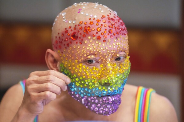 An LGBTQ participant decorate his face before a news conference in Bangkok, Thailand , Monday, May 20, 2024. (AP Photo/Sakchai Lalit)