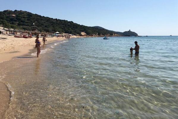 FILE - In this June 29, 2019 photo, people enjoy the white sand and pristine waters of Chia beach, on the Italian island of Sardinia, Italy. Italian media on Saturday, June 5, 2021 said customs police on the Mediterranean island issued fines of up to 3,000 euro ($3,600) to 41 persons who in recent days tried to leave the island with a total of some 100 kilos (220 pounds) of sand, seashells and beach rocks.  (AP Photo/Karl A.Ritter)