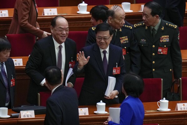 Hong Kong Chief Executive John Lee, center, waves to delegates after the opening session of the National People's Congress (NPC) at the Great Hall of the People in Beijing, Tuesday, March 5, 2024. (AP Photo/Andy Wong)