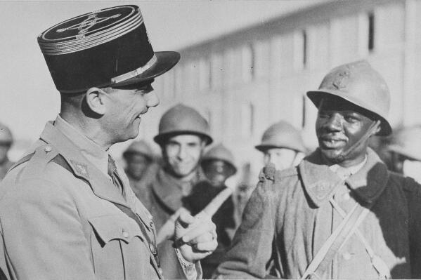 FILE - A French officer speaks to a Senegalese French Colonial soldier who has joined the Allies in North Africa under Gen. Henri Giraub on Dec. 28, 1942. Some of the last survivors in France from a colonial-era infantry corps that recruited tens of thousands of African soldiers to fight in French wars around the world will be able to live out their final days with family members back in Africa after a French government U-turn on their pension rights. (AP Photo, File)