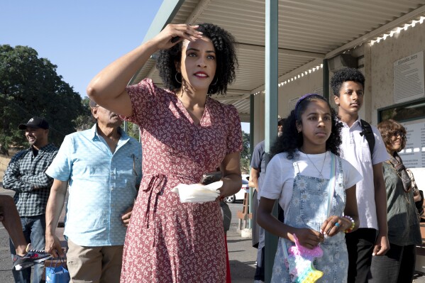 Jacq'lene Massey shields her eyes from the sun as she watches for her husband, Folsom State Prison inmate Gerald Massey, to be released with the couple's children, Grace, 9, center, and Brian, 12, right in Folsom, Calif., Monday, July 3, 2023. Gerald Massey was released on parole after serving nine years of a 15-to-life sentence for a drunk driving incident that killed his close friend. (AP Photo/Rich Pedroncelli)