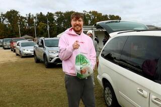 This image released by Beast Philanthropy Productions shows Jimmy Donaldson, better known as MrBeast, during a turkey giveaway at Pitt County Fairgrounds in Greenville, N.C. on Nov. 7 2021. The widely popular YouTube video maker has built an unusual charity playbook that leverages his fame and skills with the goal to end hunger. (Beast Philanthropy Productions via AP)