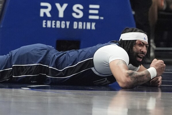 Dallas Mavericks forward Anthony Davis lays on the floor after getting injured during the first half of an NBA basketball game against the Atlanta Hawks in Dallas, Wednesday, April 2, 2025. (AP Photo/LM Otero)