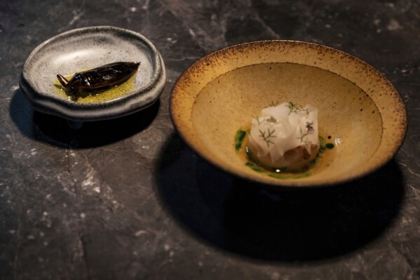 Dishes made with fish sauce are prepared at Chapter Dining, a fine dining restaurant, including a water bug, left, on March 1, 2025, in Hanoi, Vietnam. (AP Photo/Yannick Peterhans)