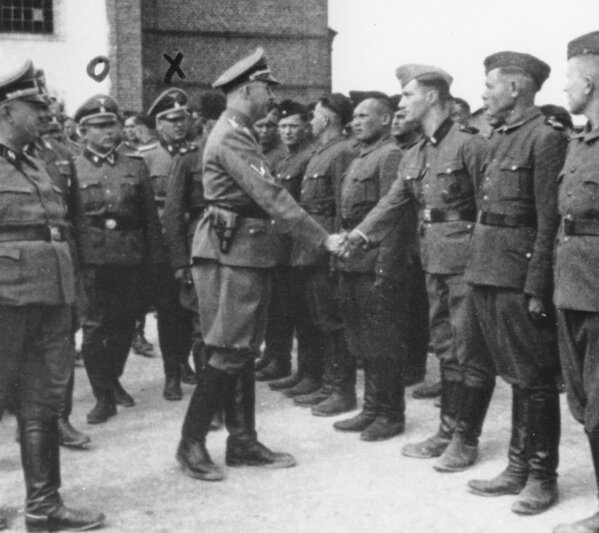 
              This 1942 photo provided by the the public prosecutor's office in Hamburg via the United States Holocaust Memorial Museum, shows Heinrich Himmler, center left, shaking hands with new guard recruits at the Trawniki concentration camp in Nazi occupied Poland. Trawniki is the same camp, where some time after this photo was made, Jakiw Palij trained and served as a guard. The White House says that Palij, a 95-year-old former Nazi concentration camp guard has been deported to Germany, 14 years after a judge ordered his expulsion. In a statement, the White House said the deportation of Palij, who lived in New York City, was carried out early Tuesday Aug. 21, 2018.  (Public prosecutor's office in Hamburg via the United States Holocaust Memorial Museum via AP)
            