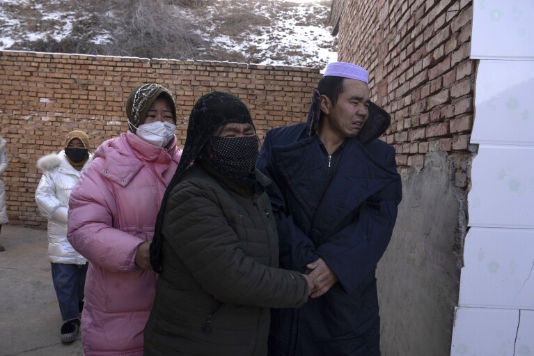 Ma Lianqiang, right, grieves with other family members as the body of his wife Han Suofeiya who was killed in an earthquake is prepared for burial in Yangwa village near Dahejia town in northwestern China's Gansu province, Wednesday, Dec. 20, 2023. (AP Photo/Ng Han Guan)