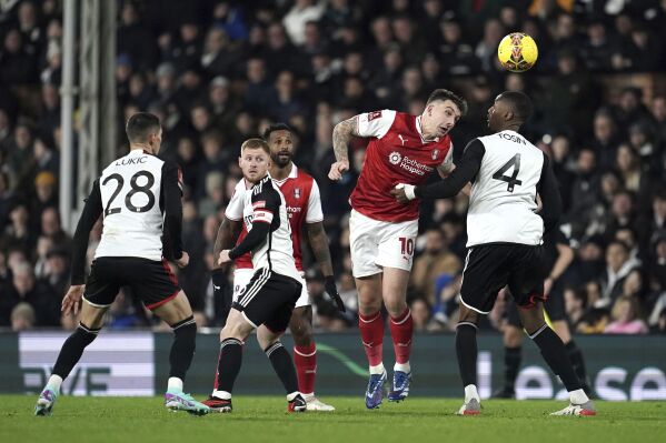 Rotherham United's Jordan Hugill heads the ball over Fulham's Tosin Adarabioyo, right, battle for the ball during the English FA Cup third round soccer match between Fulham and Rotherham United at Craven Cottage, London, Friday Jan. 5, 2024. (Adam Davy/PA via AP)