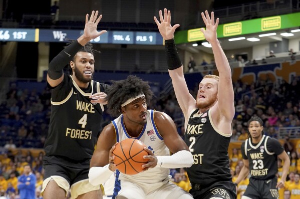Pittsburgh forward Blake Hinson, center, is double teamed by Wake Forest forward Efton Reid III (4) and guard Cameron Hildreth (2) during the first half of an NCAA college basketball game Wednesday, Jan. 31, 2024, in Pittsburgh. (AP Photo/Matt Freed)