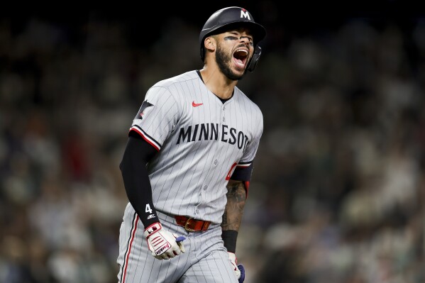 Minnesota Twins' Carlos Correa celebrates after hitting a go-ahead two-run home run during the 10th inning of a baseball game against the Seattle Mariners Friday, May 30, 2025, in Seattle. DaShawn Keirsey Jr. also scored. (AP Photo/Ryan Sun)