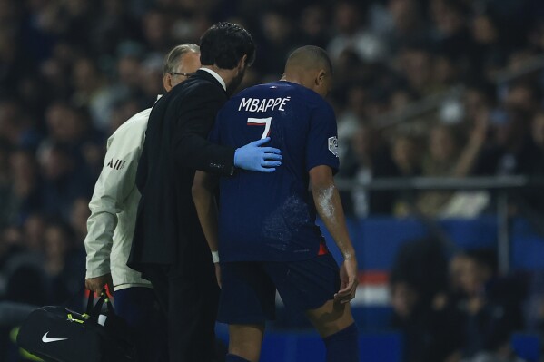 PSG's Kylian Mbappe leaves the pitch with an injury during the French League One soccer match between Paris Saint Germain and Olympique de Marseille at Parc des Princes stadium in Paris, France, Sunday, Sept. 24, 2023. (AP Photo/Aurelien Morissard)