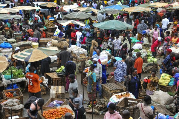 Traders sell food at a busy market, which are no longer permitted to sell any non-food items in an attempt to halt the spread of the new coronavirus, in Kampala, Uganda Thursday, March 26, 2020. The new coronavirus causes mild or moderate symptoms for most people, but for some, especially older adults and people with existing health problems, it can cause more severe illness or death. (AP Photo/Ronald Kabuubi)