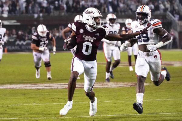 Mississippi State wide receiver Rara Thomas (0) smiles next to Auburn linebacker Derick Hall (29) on the way to a touchdown after a reception during the second half of an NCAA college football game in Starkville, Miss., Saturday, Nov. 5, 2022. Mississippi State won 39-33 in overtime. (AP Photo/Rogelio V. Solis)