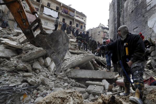 FILE - Syrian Civil Defense workers and security forces search through the wreckage of collapsed buildings after a devastating earthquake rocked Syria and Turkey, in Aleppo, Syria, Monday, Feb. 6, 2023. For years, the people of Aleppo bore the brunt of bombardment and fighting when their city, once Syria's largest and most cosmopolitan, was one of the civil war's fiercest battle zones. Even that didn't prepare them for the new devastation and terror wreaked by this week's earthquake. (AP Photo/Omar Sanadiki, File)