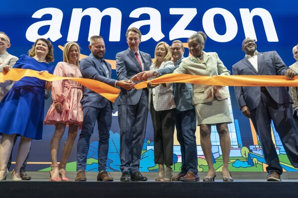 Virginia Gov. Glenn Youngkin, center, with Holly Sullivan, Vice President of Economic Development at Amazon, center right, cut the ribbon during a grand opening ceremony at Amazon's second headquarters, HQ2, in Arlington, Va., June 15, 2023. Two new operations facilities are coming to Virginia Beach, expected to eventually employ over 1,000 people, Gov. Youngkin announced Monday, Sept. 25. From right, Christian Dorsey, Chair of the Arlington County Board of Directors, Lieutenant Gov. of Virginia Winsome Earle-Sears, John Schoettler, Vice President of Global Real Estate and Facilities at Amazon, Holly Sullivan, Gov. Glenn Youngkin, Brian Huseman, Vice President of Public Policy and Community Engagement at Amazon, Youngkin's wife Suzanne Youngkin and Virginia State Sen. Barbara Favola, D-Arlington. (AP Photo/Jacquelyn Martin, file)