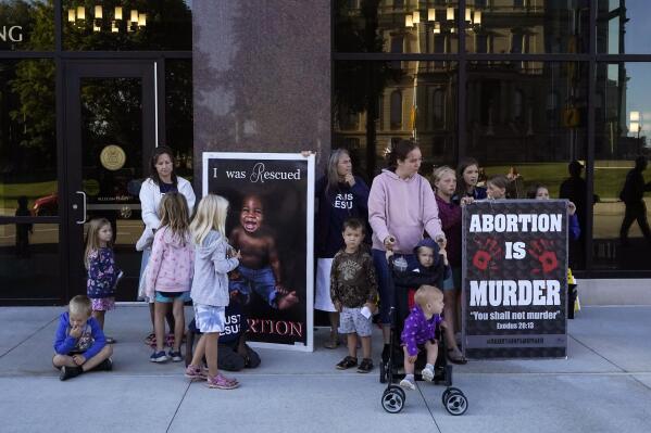 Abortion opponents are seen outside as the Michigan Board of State Canvassers meet during a hearing, Wednesday, Aug. 31, 2022, in Lansing, Mich. The board is scheduled to decide whether a ballot initiative that seeks to enshrine abortion rights into Michigan's constitution should go to voters in November. (AP Photo/Carlos Osorio)