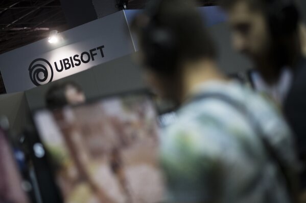 This Nov.3 2017 file photo shows visitors playing Assassin's Creed video game at the Ubisoft stand at the Paris Games Week in Paris. French gaming giant Ubisoft is parting ways with its creative director and two other executives following an internal investigation of misconduct and media reports of sexual harassment. (AP Photo/Kamil Zihnioglu, File)