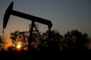 FILE - In this Feb. 19, 2015 file photo, the sun sets behind an oil well in a field near El Tigre, a town within Venezuela's Hugo Chavez oil belt, formally known as the Orinoco Belt. Venezuelan oil exports to the U.S. have declined steadily over the years, falling particularly sharply over the past decade as its production plummeted amid its long economic and political crisis. (AP Photo/Fernando Llano, File)