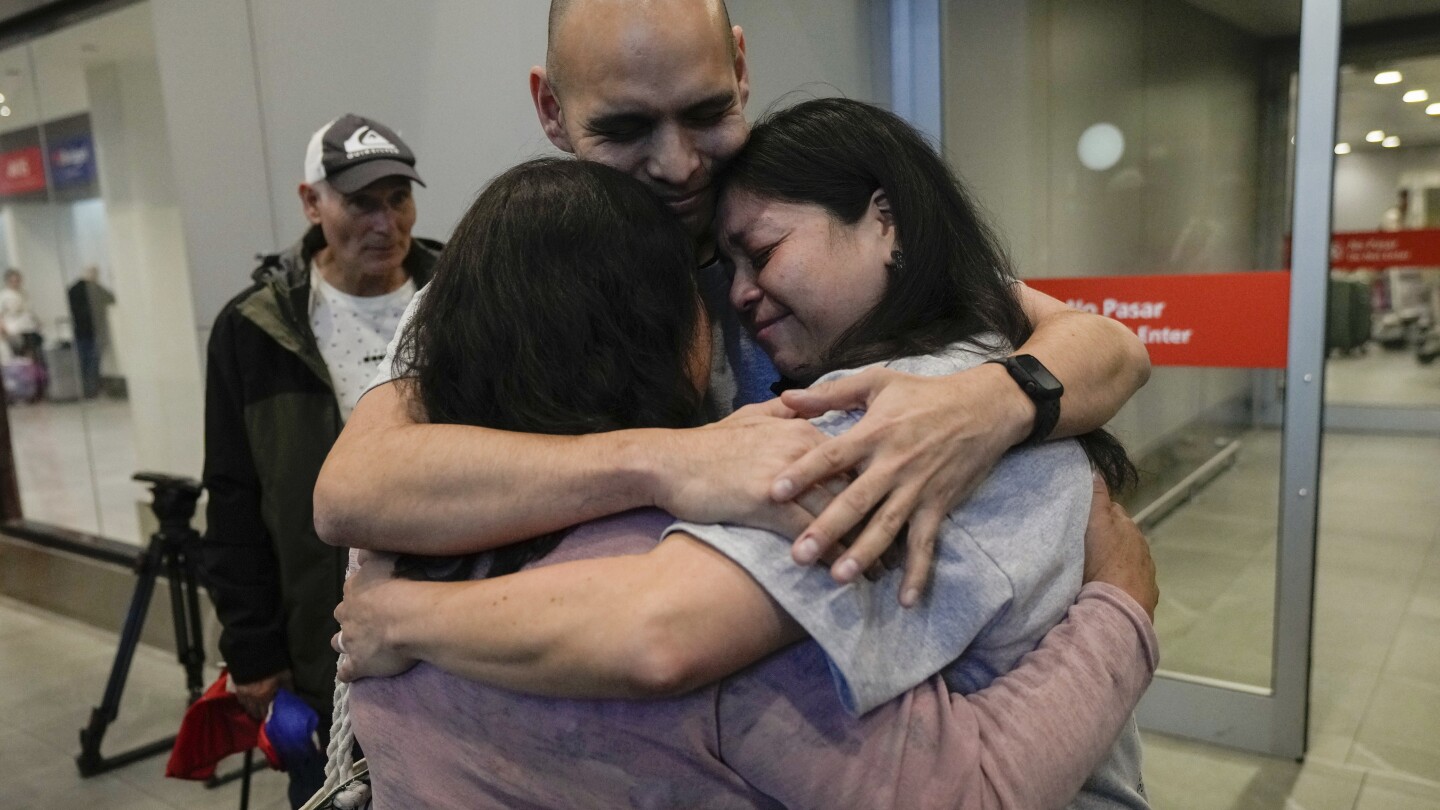 Sean Ours, center, who lives in Alexandria, VA, and Emily Reid, right who lives in Raleigh, NC, embrace for the first time their biological mother Sar