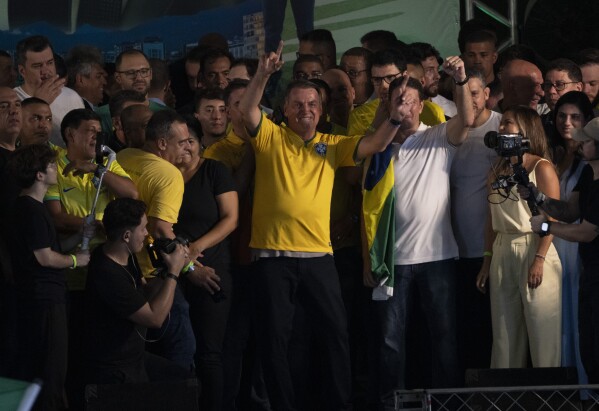 Бывший президент Бразилии Жаир Болсонару приветствует сторонников во время предвыборной кампании, посвященной выдвижению предварительной кандидатуры кандидата в мэры, в Рио-де-Жанейро, Бразилия, суббота, 16 марта 2024 года. (AP Photo/Silvia Izquierdo)
