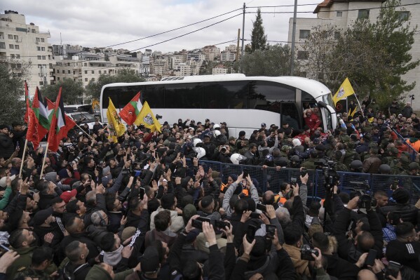 Palestinian prisoners are greeted as they exit a Red Cross bus after being released from Israeli prison following a ceasefire agreement between Israel and Hamas, in the West Bank city of Ramallah, Saturday Feb. 8, 2025. (AP Photo/Mahmoud Illean)