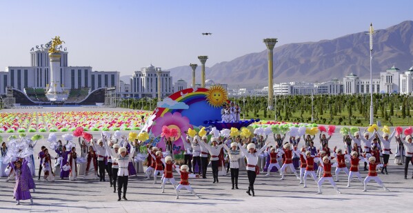 Actors wearing Turkmen national costumes dance during a ceremony of the officially opening of the new Arkadag city, about 30 kilometers (20 miles) south of the capital Ashgabat, Turkmenistan, Thursday, June 29, 2023. The president of Turkmenistan on Thursday officially opened a vast multibillion-dollar development hailed as the isolated country's first "smart city" and named after the president's father who established a pervasive cult of personality when he was the longtime ruler. (AP Photo/Alexander Vershinin)