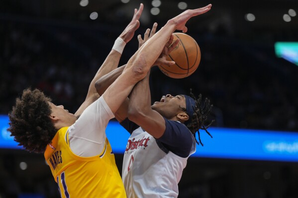 Los Angeles Lakers center Jaxson Hayes, left, blocks a shot-attempt by Washington Wizards guard Bilal Coulibaly, right, during the first half of an NBA basketball game Thursday, Jan. 30, 2025, in Washington. (AP Photo/Jess Rapfogel)
